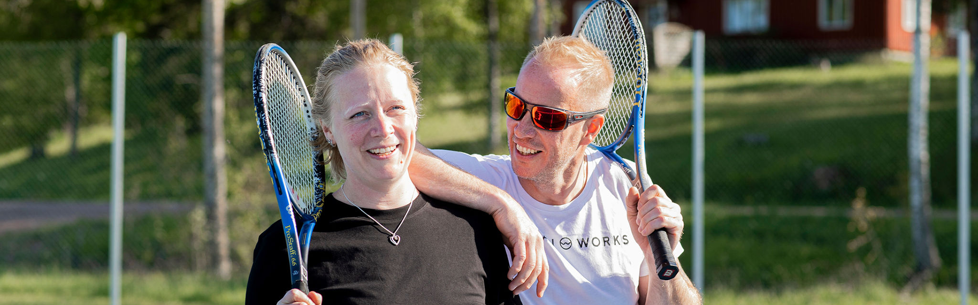 Ett par som håller i varsitt tennis rack